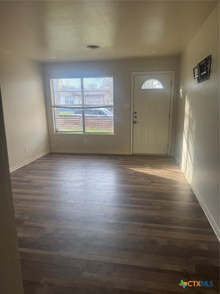 904 Houston Street Killeen, TX 76541 - Photo 3 of 17 an empty room with wooden floor and windows