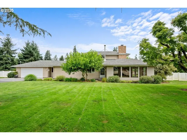 a front view of a house with a yard and trees