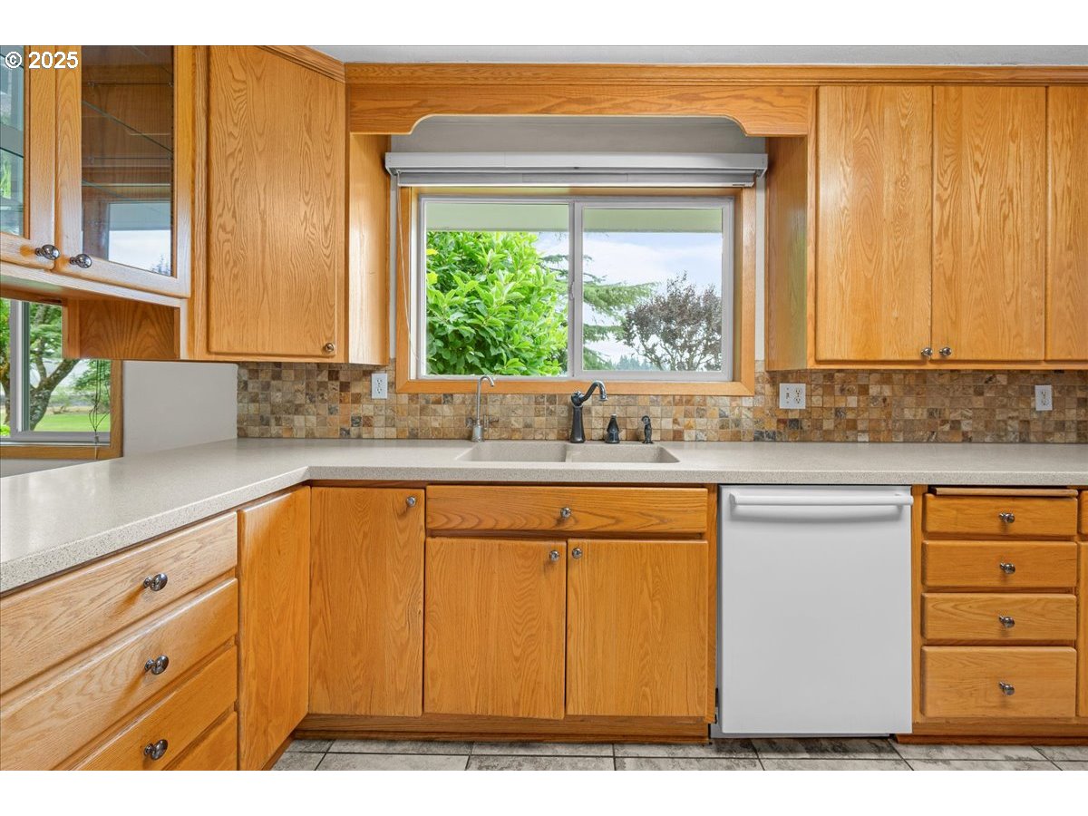 11623 Broadacres Road Northeast Hubbard, OR 97032 - Photo 11 of 48 a kitchen with stainless steel appliances white cabinets and a large window
