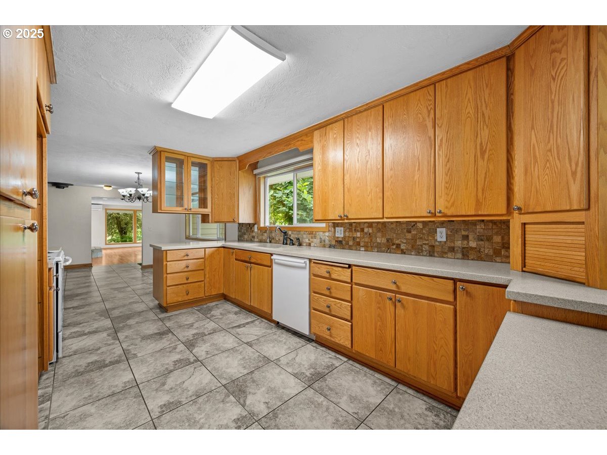 11623 Broadacres Road Northeast Hubbard, OR 97032 - Photo 13 of 48 a kitchen with granite countertop a sink cabinets and window