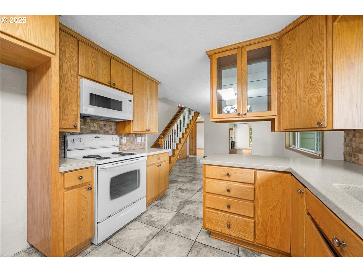 11623 Broadacres Road Northeast Hubbard, OR 97032 - Photo 14 of 48 a kitchen with stainless steel appliances granite countertop a stove a sink and a microwave