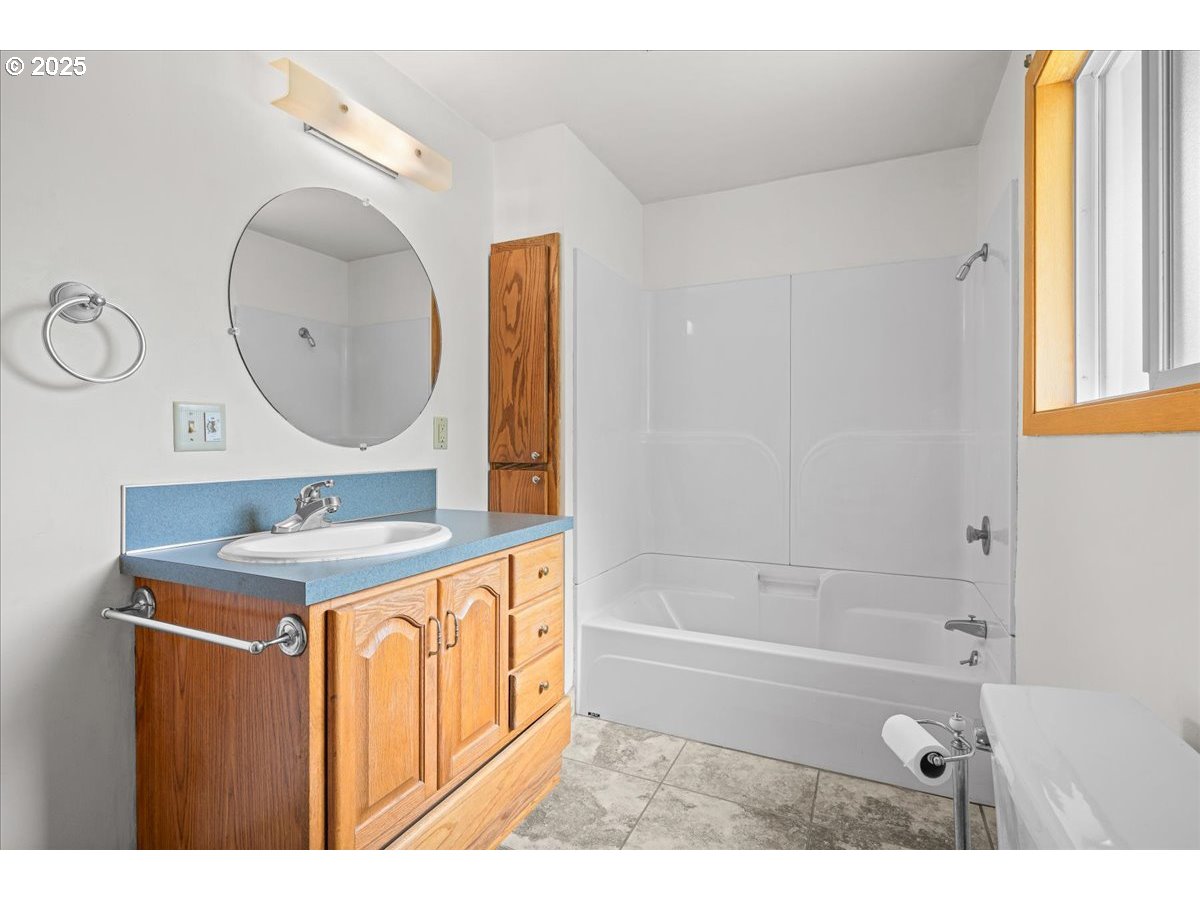 11623 Broadacres Road Northeast Hubbard, OR 97032 - Photo 21 of 48 a bathroom with a sink a mirror and a bathtub
