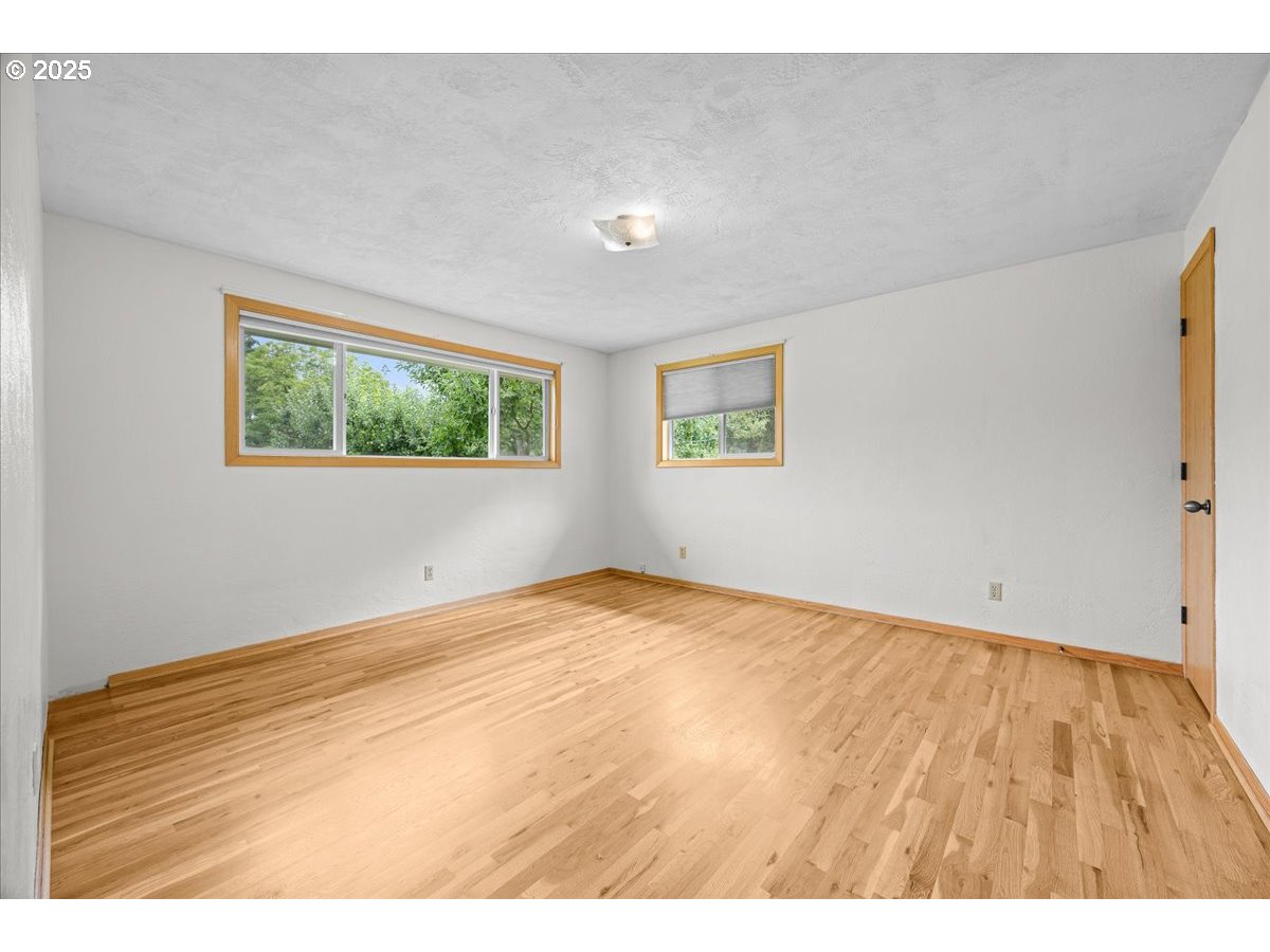 11623 Broadacres Road Northeast Hubbard, OR 97032 - Photo 26 of 48 a view of an empty room with wooden floor and a window