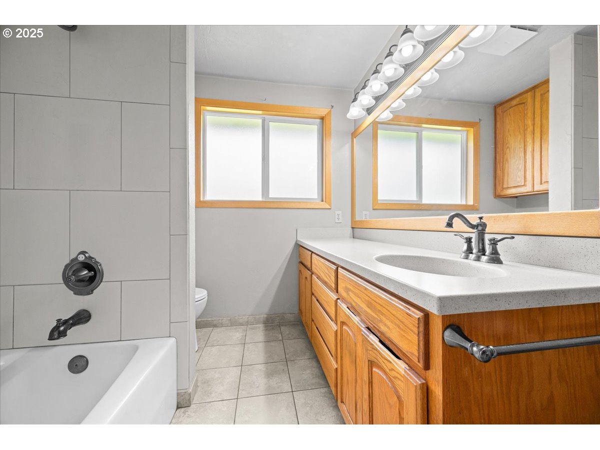 11623 Broadacres Road Northeast Hubbard, OR 97032 - Photo 28 of 48 a bathroom with a sink a mirror and a bathtub