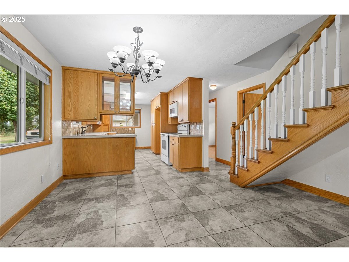 11623 Broadacres Road Northeast Hubbard, OR 97032 - Photo 6 of 48 a view of a livingroom with kitchen and natural light