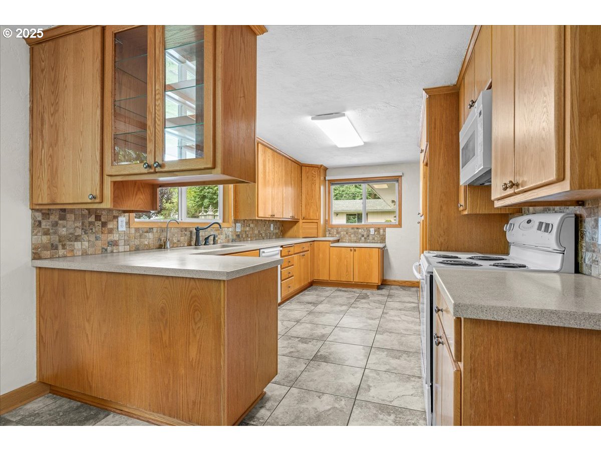 11623 Broadacres Road Northeast Hubbard, OR 97032 - Photo 8 of 48 a kitchen with stainless steel appliances granite countertop a sink stove and cabinets