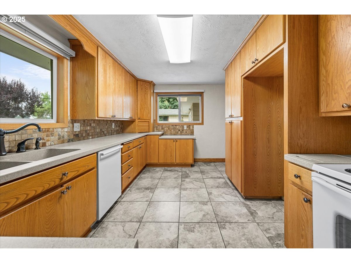 11623 Broadacres Road Northeast Hubbard, OR 97032 - Photo 10 of 48 a kitchen with a sink a refrigerator and window