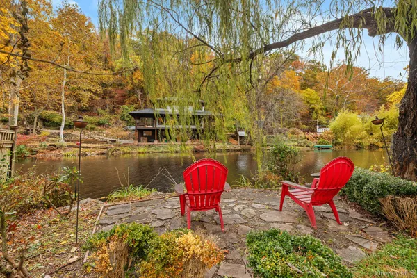 a view of a lake with a chairs and table in the patio