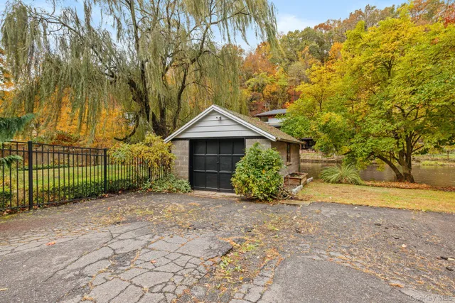 a view of a backyard with large trees and wooden fence