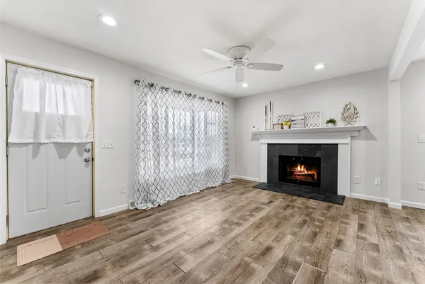 a view of an empty room with a fireplace and a window