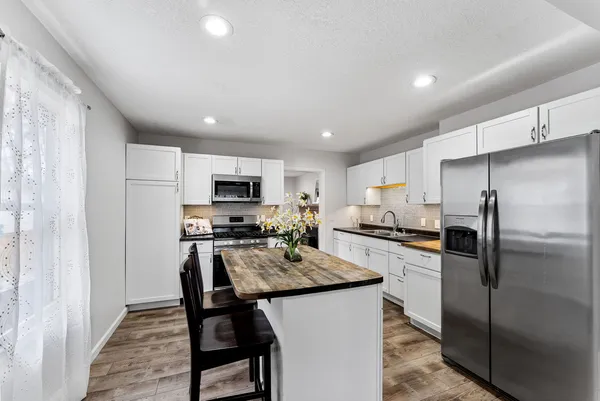 a kitchen with granite countertop a refrigerator stove microwave and sink