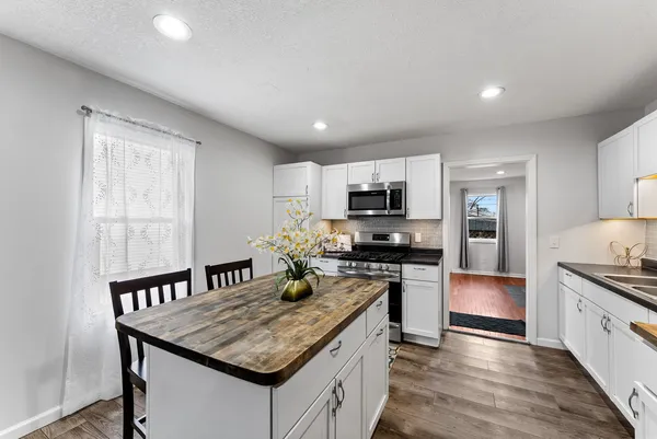 a kitchen with stainless steel appliances granite countertop a stove refrigerator sink and microwave