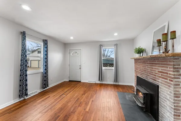 a view of empty room with wooden floor and fireplace