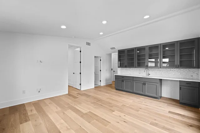 a large kitchen with stainless steel appliances granite countertop a large counter top a sink and a refrigerator