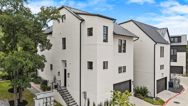 a view of a white house next to a yard