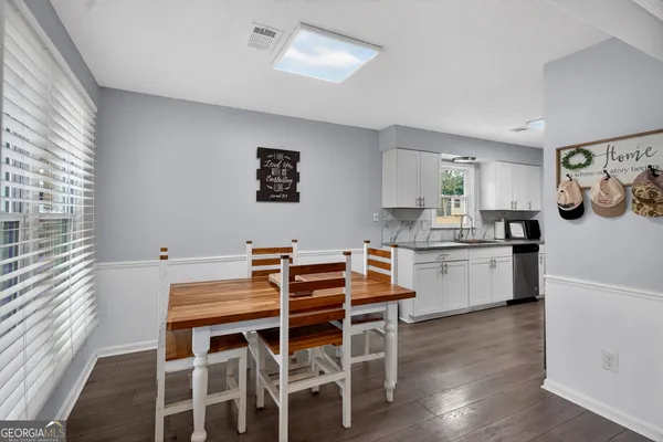 a kitchen with a table chairs cabinets and wooden floor