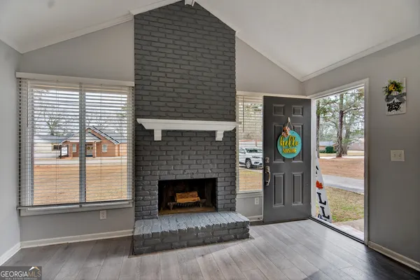 a living room with a fireplace and a wooden floor