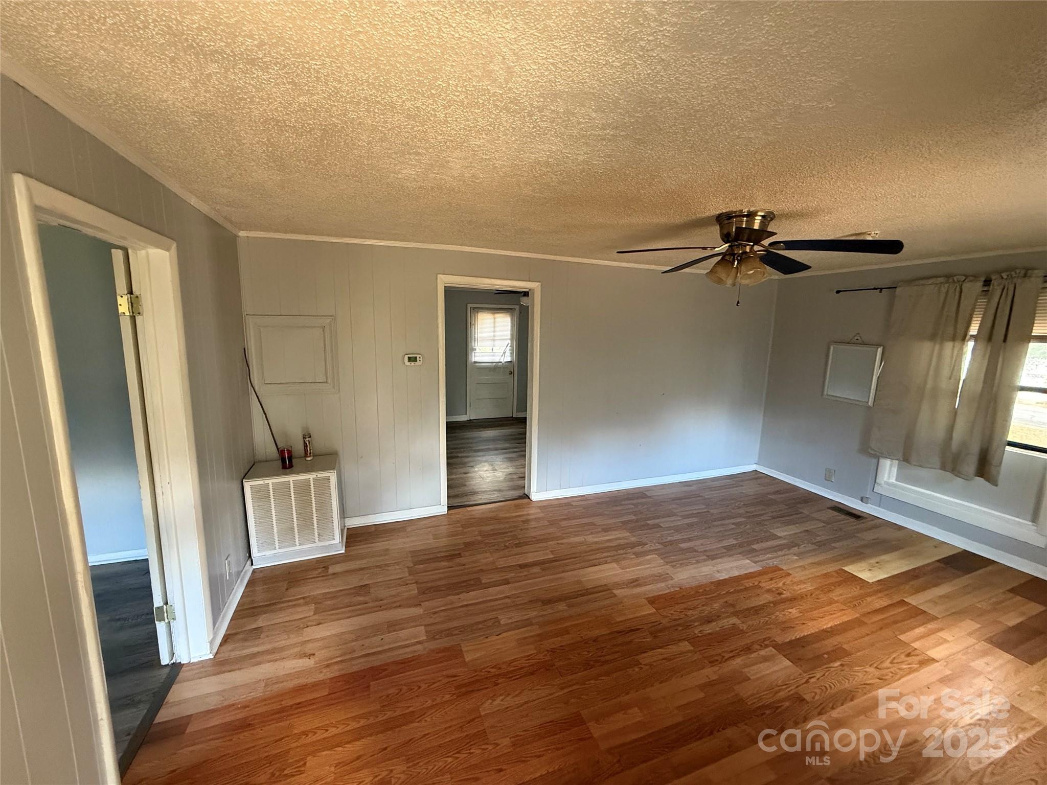 175 Rush Loop Road Mount Gilead, NC 27306 - Photo 2 of 10 a view of empty room with wooden floor and fan