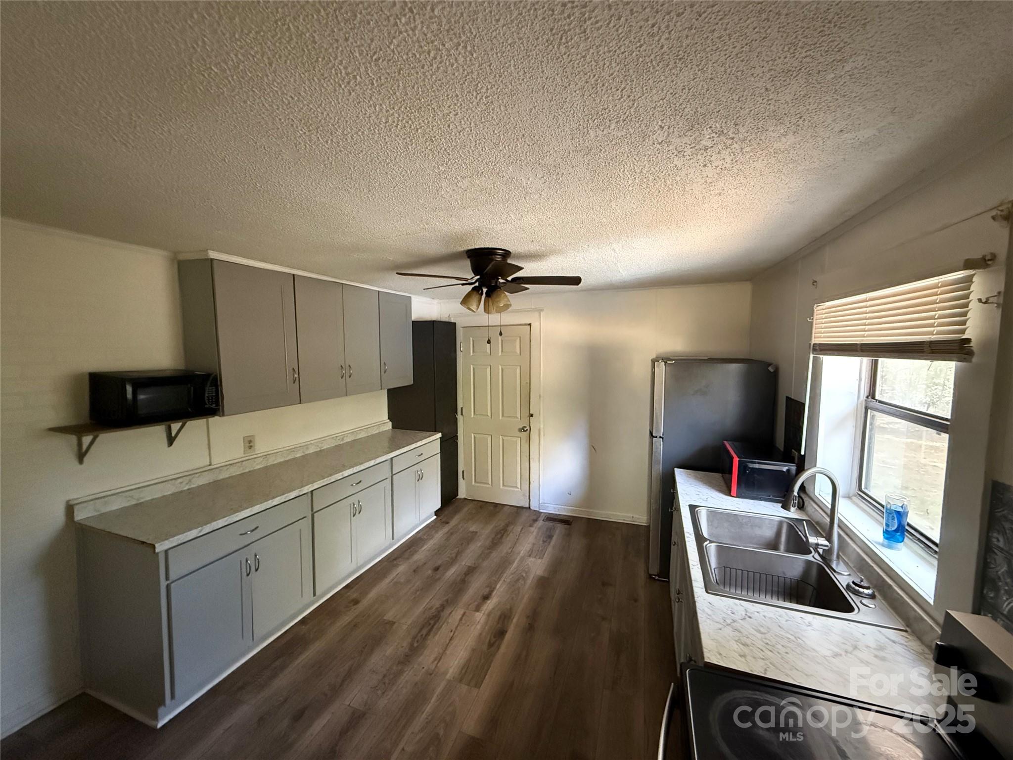 175 Rush Loop Road Mount Gilead, NC 27306 - Photo 5 of 10 a large white kitchen with a sink stainless steel appliances and a large window