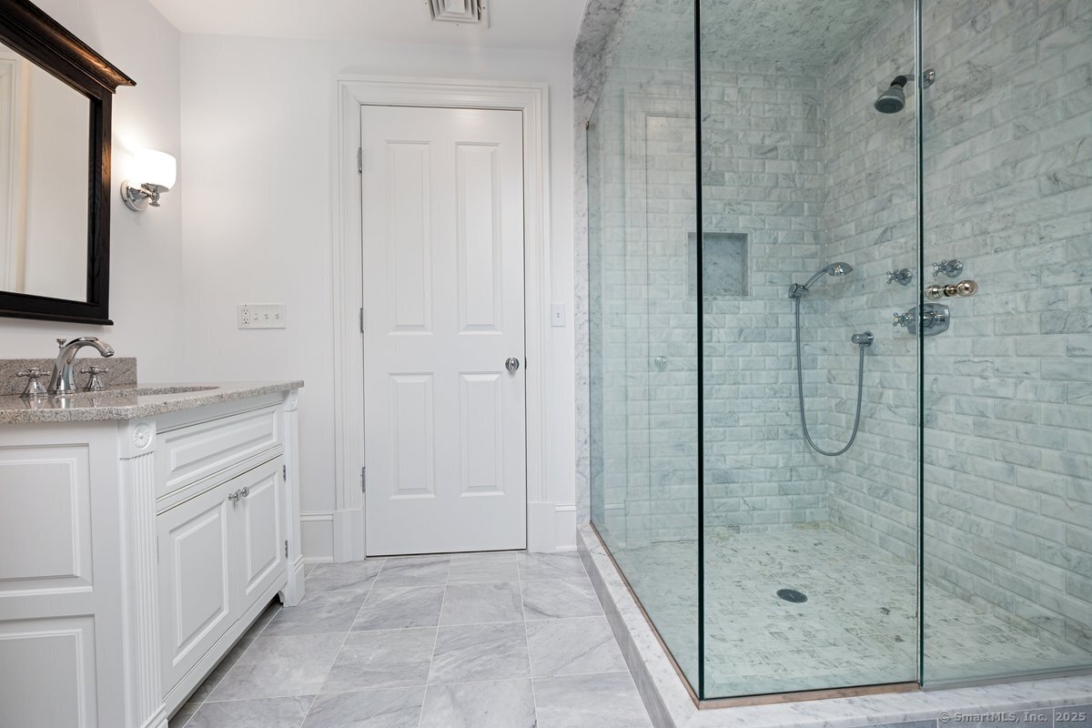 174 Branchville Road Ridgefield, CT 06877 - Photo 28 of 40 a bathroom with a granite countertop sink a mirror and shower