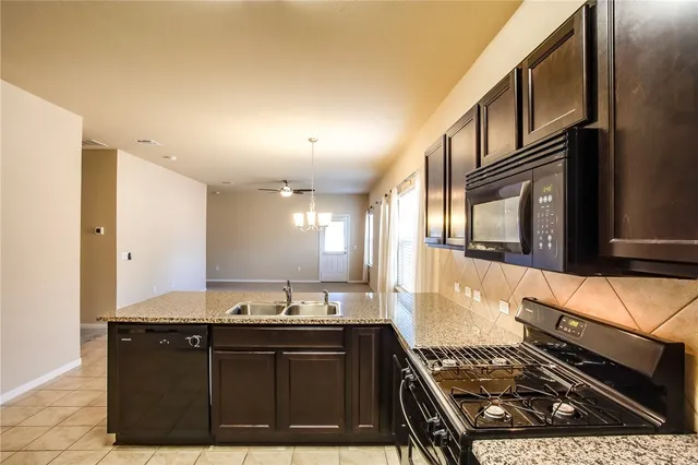 a kitchen with stainless steel appliances granite countertop a sink and a stove top oven