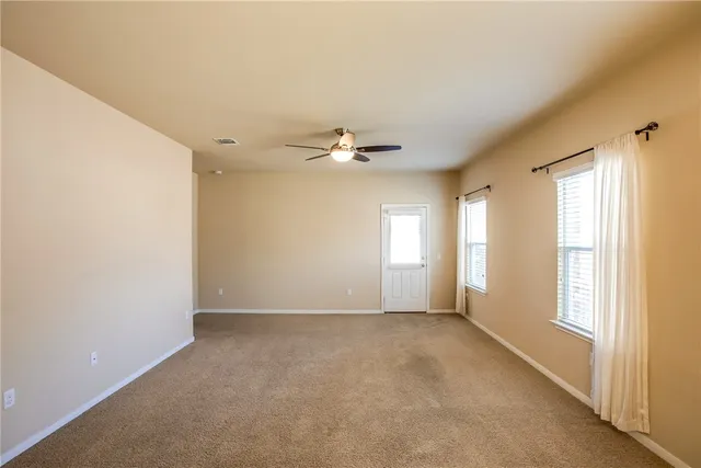a view of a livingroom with a furniture ceiling fan and window