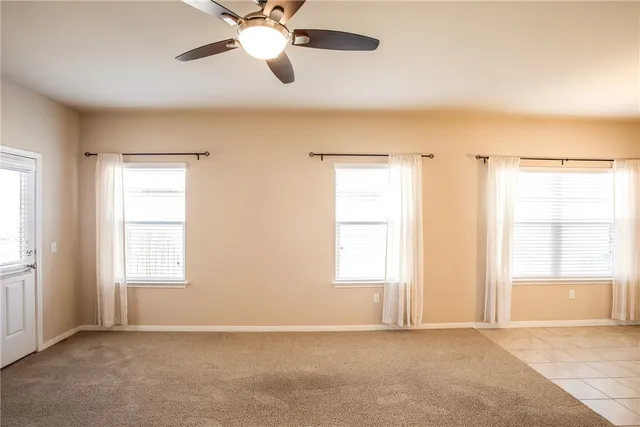 a view of a hallway with a ceiling fan and window