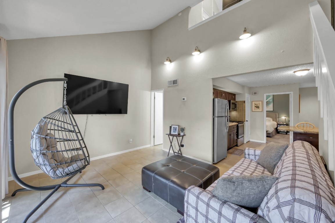 12900 Walden Road, Unit 620 Montgomery, TX 77356 - Photo 7 of 21 a living room with furniture a flat screen tv and a chandelier