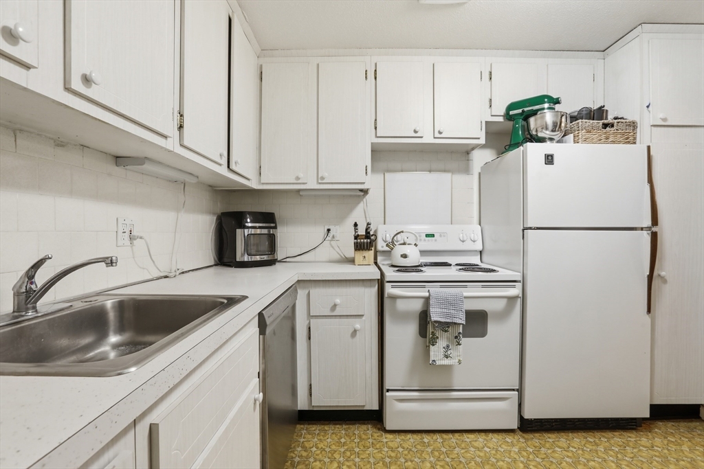 1 Colonial Drive, Unit B1 Andover, MA 01810 - Photo 7 of 14 a white refrigerator freezer sitting inside of a kitchen