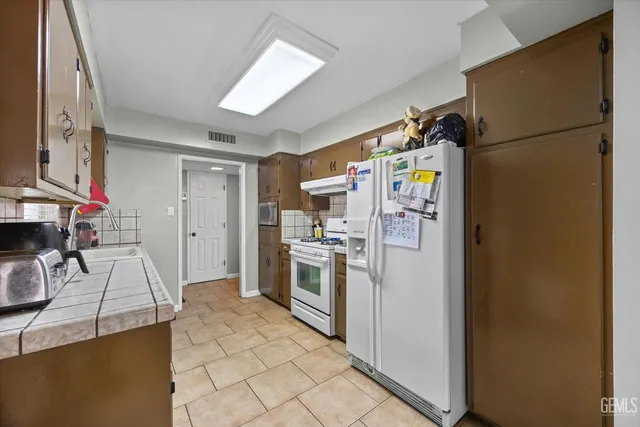a kitchen with a refrigerator and a stove top oven