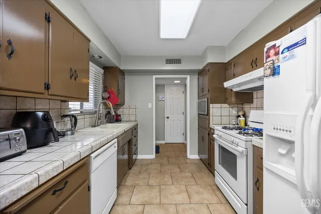 a kitchen with stainless steel appliances granite countertop a stove and a sink