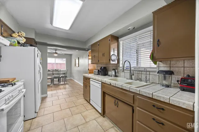 a kitchen with stainless steel appliances granite countertop a sink counter space cabinets and a window