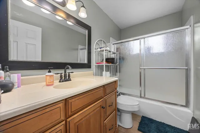 a bathroom with a sink a toilet and a large mirror