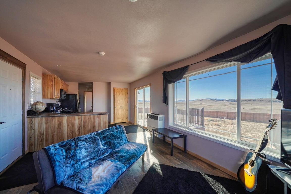 608 Rio Blanco Road Hartsel, CO 80449 - Photo 5 of 26 a living room with furniture a large window and wooden floor