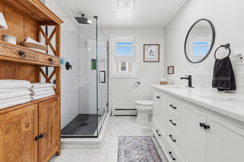58 Bowler Street Fall River, MA 02723 - Photo 13 of 32 a spacious bathroom with a sink a mirror a toilet and a shower