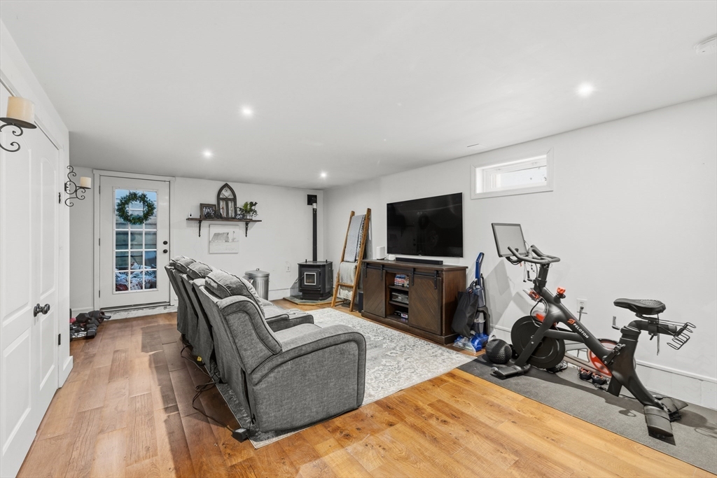 58 Bowler Street Fall River, MA 02723 - Photo 20 of 32 a living room with furniture a flat screen tv and gym equipment