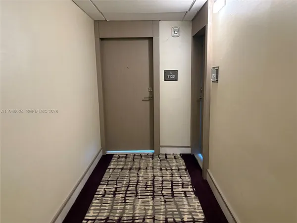 a view of a hallway with mirror and furniture
