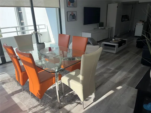 a view of a dining room with furniture and a flat screen tv