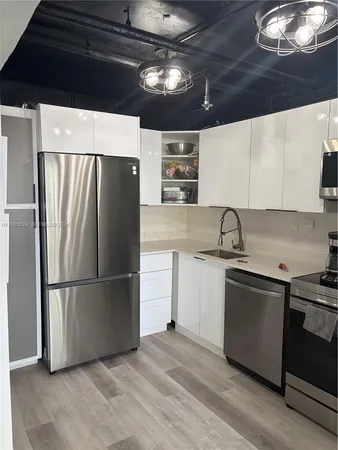 a kitchen with stainless steel appliances granite countertop a refrigerator a sink and a stove