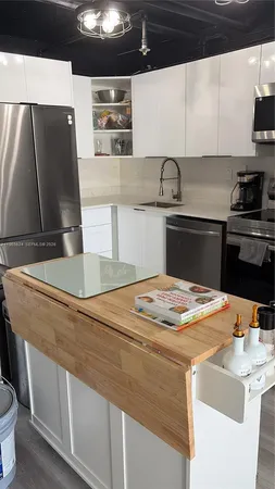 a kitchen with stainless steel appliances wooden floor sink and stove