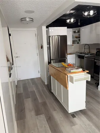 a kitchen that has a sink stainless steel appliances a refrigerator and a stove