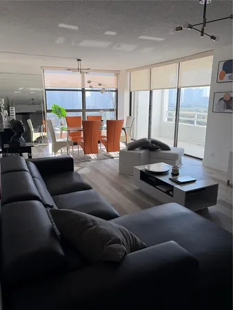 a living room with furniture and floor to ceiling window