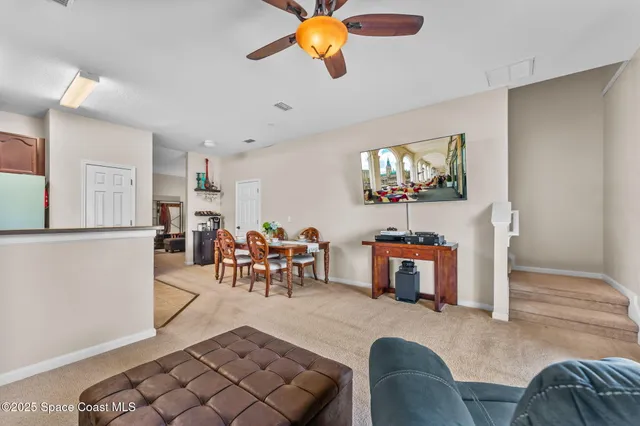a living room with furniture a dining table and a chandelier