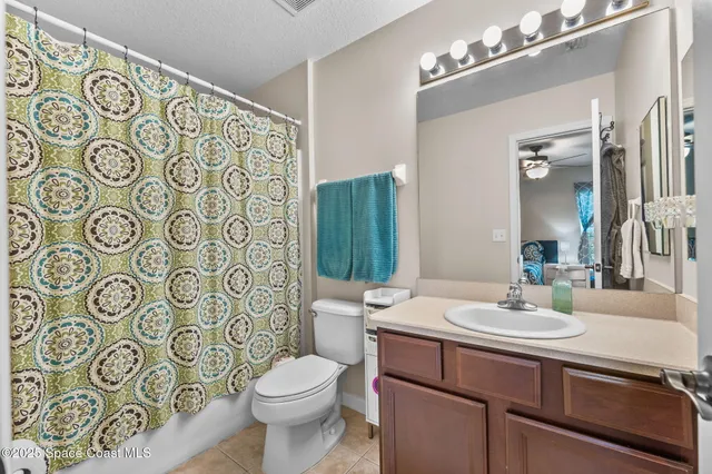 a bathroom with a sink a toilet and shower curtain