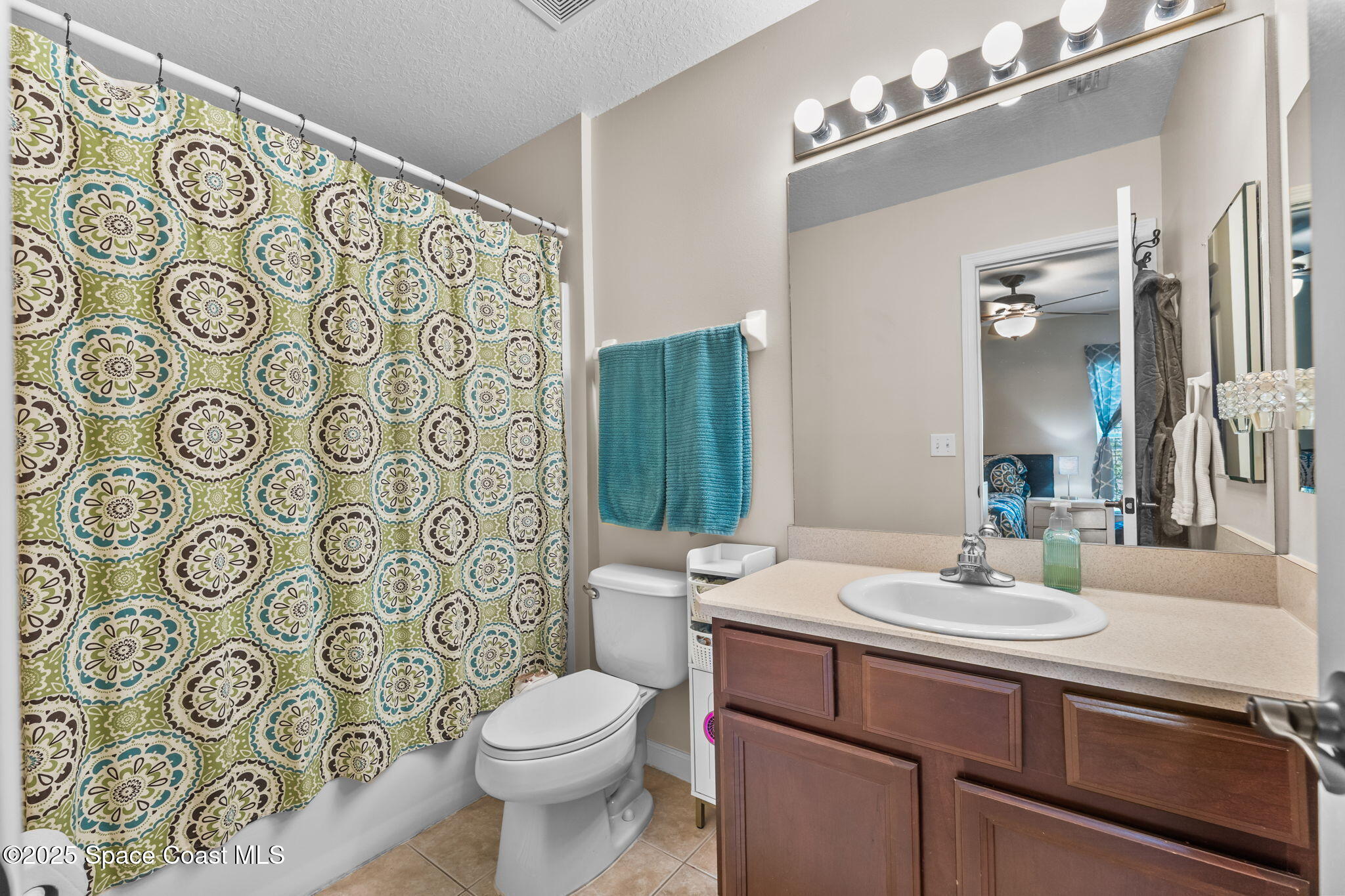2690 Revolution Street, Unit 104 Melbourne, FL 32935 - Photo 18 of 35 a bathroom with a sink a toilet and shower curtain