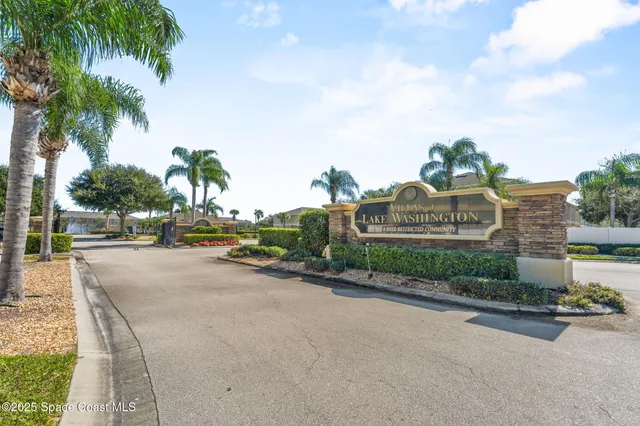 a view of a street with a cars parked and small yard