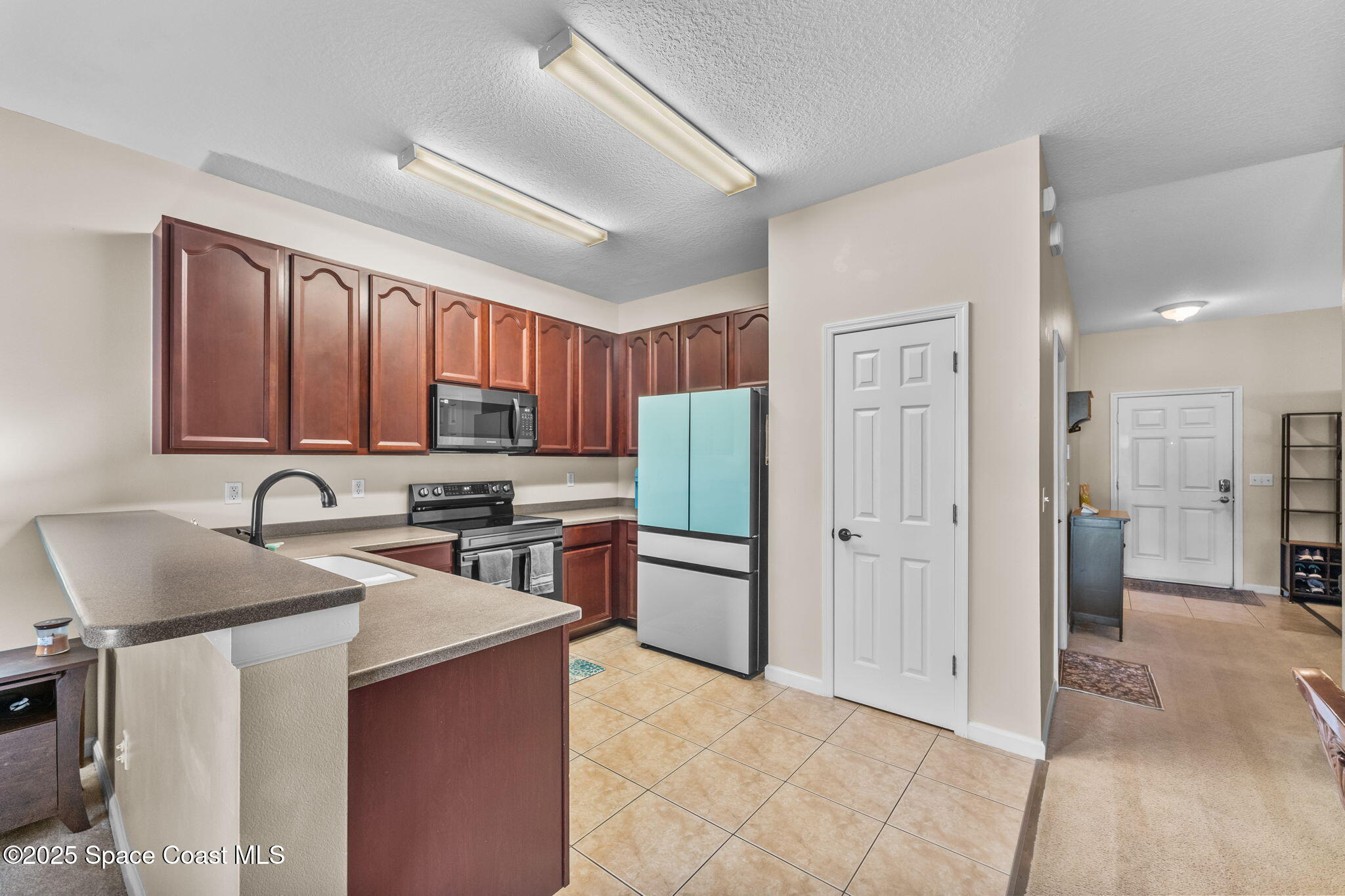 2690 Revolution Street, Unit 104 Melbourne, FL 32935 - Photo 7 of 35 a kitchen with stainless steel appliances granite countertop a refrigerator stove and sink