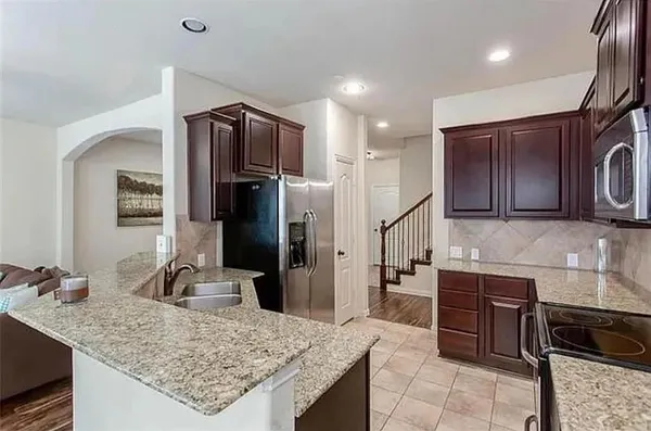 a kitchen with stainless steel appliances granite countertop wooden cabinets and a granite counter tops