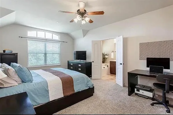 a spacious bedroom with a bed and a chandelier