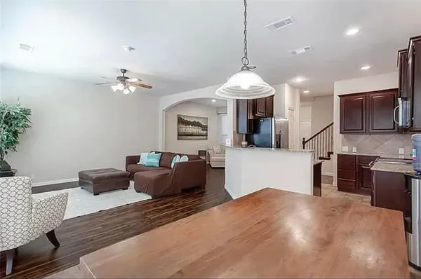 a living room with furniture a chandelier and a kitchen view
